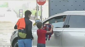 Andrés Iniesta hace feliz a un niño a su llegada a la ciudad deportiva del FC Barcelona