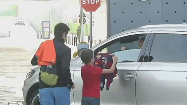 Andrés Iniesta hace feliz a un niño a su llegada a la ciudad deportiva del FC Barcelona